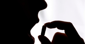 silhouette of a person taking a pill to illustrate the concept of a fecal transplant pill