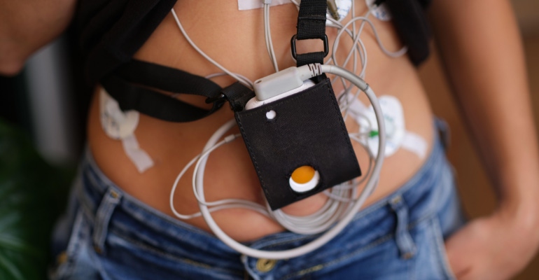 Patient standing with holter electrocardiogram monitor closeup - this is an example of a medical device that could be