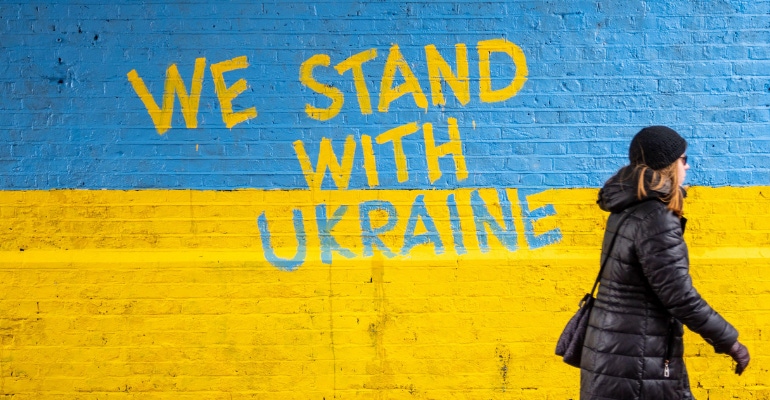 Blue and yellow mural painted on a brick wall in the UK in support of Ukraine
