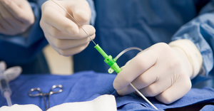 close up photograph of a clinician performing a catheter-based procedure in a cardiac cath lab