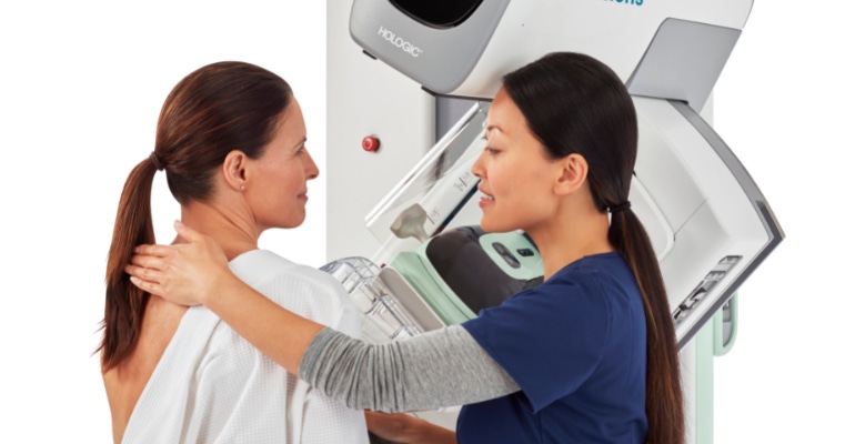 Hologic breast health imaging system with a clinician imaging a patient using the machine