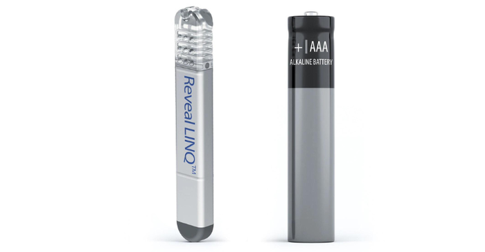 photo of a Medtronic Linq II insertable cardiac monitor shown upright beside a AAA alkaline battery for size comparison.