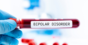photo of a clinician wearing a latex glove and holding a vial of blood labeled "BIPOLAR DISORDER"