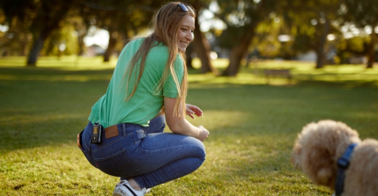 Medtronic diabetes patient playing in a park with her dog, the Medtronic MiniMed 780G automated insulin delivery system