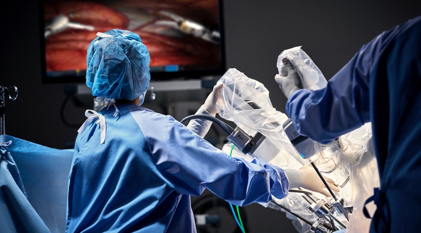 Operating room staff using a da Vinci Xi surgical robotic system during a procedure.