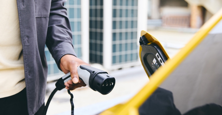 close up of someone using an electric vehicle charging station