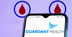 Guardant Health logo shown on a smart phone with a blood drop icon in the background
