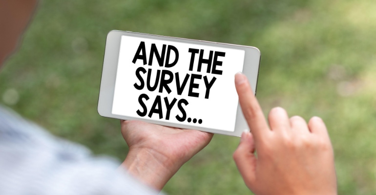Photo illustration of a man holding a smartphone with the text "And the survey says" showing on the screen.