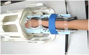The forearm of a healthy volunteer in the wrist harness is about to be visualized using 'active MRI.' The harness slides into the MR coil structure to perform the imaging sequence. (Image courtesy of Boutin et al.)