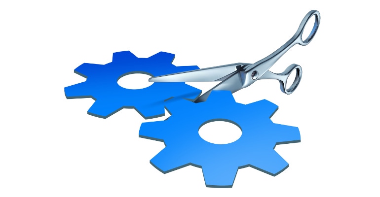 a pair of scissors cutting in two pieces a paper cut out shaped as gears and cogs representing the financial split of assets
