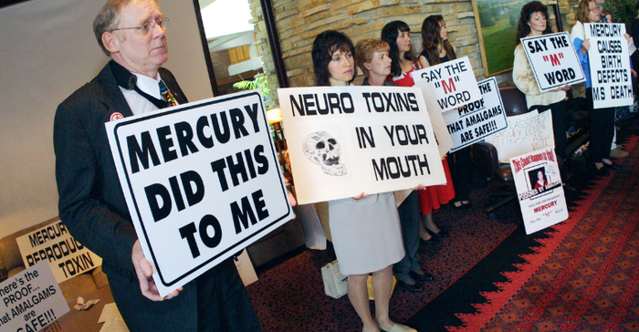 Attendees display various anti-Mercury signage during a press conference September 7, 2001 in Oak Brook, IL. 