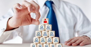 Image showing a business man flicking the "CEO block" off a pyramid of blocks