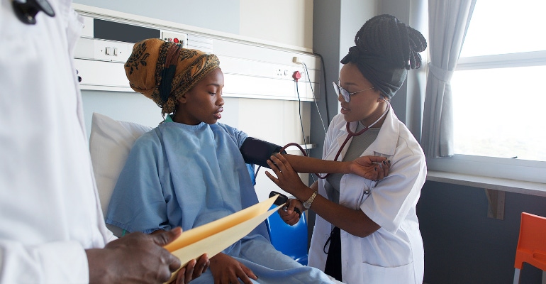 African doctor checks the blood pressure on a young African hospital patient in Cape Town, South Africa.