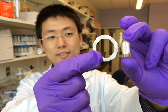 Photo of Shiyi Zhang, postdoc at Koch Institute and co-lead author, holding a ring-shaped prototype, which can be folded into a swallowable capsule (shown on the right) for safe oral delivery .