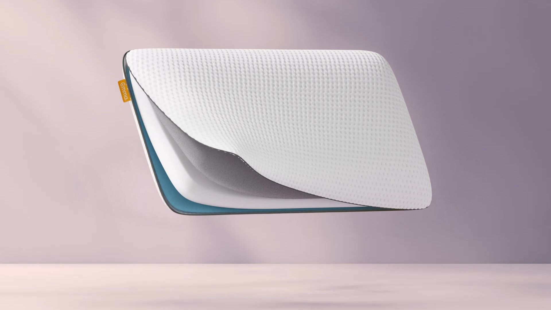 Original Cooling Adapt Kussen met witte geribbelde toplaag, grijze middenlaag en blauwe onderlaag, gestapeld en zwevend voor een zachte paarse achtergrond; aan de zijkant zichtbaar oranje Emma-label.