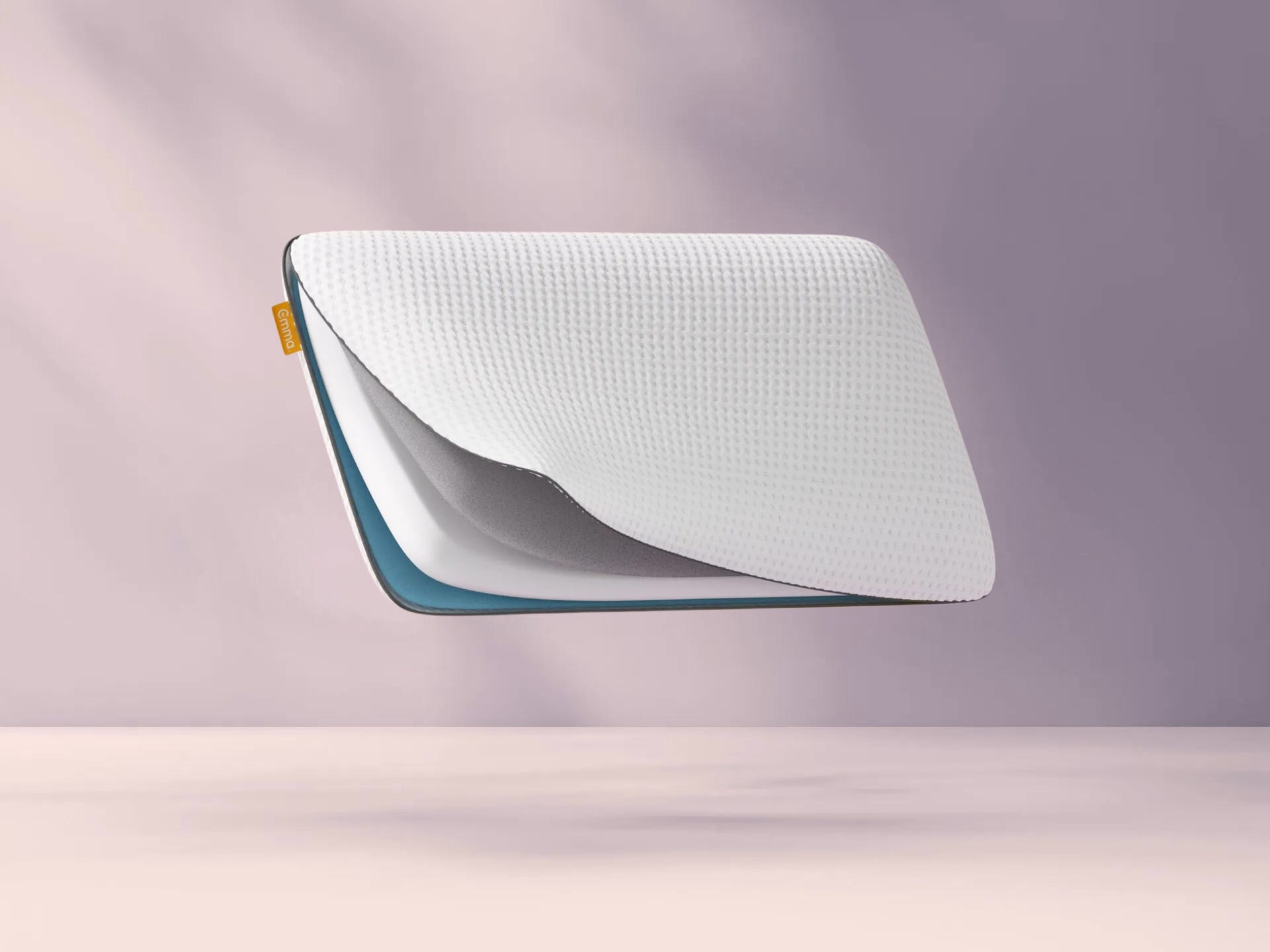 Emma Diamond Kussen met witte gewafelde hoes en zichtbaar binnenmateriaal, zwevend tegen een lichtpaarse achtergrond met oranje Emma-label aan de zijkant.