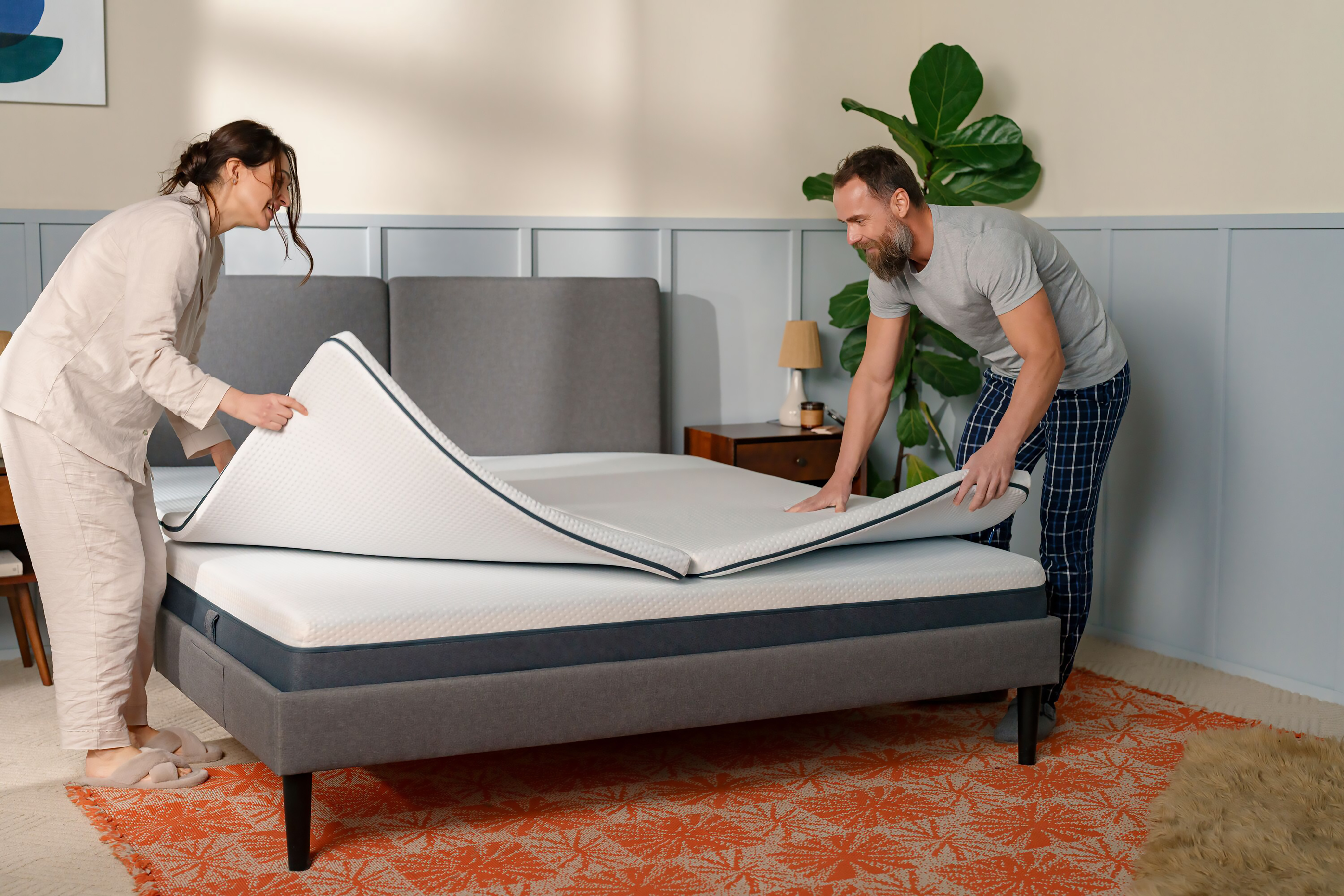 Paar legt das Topper auf das Bett