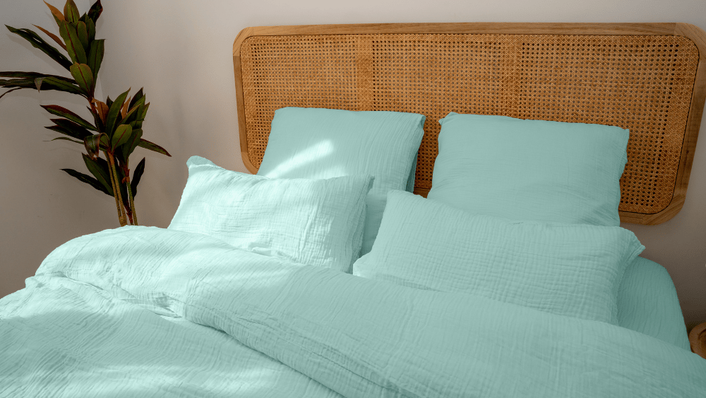 Lit avec couette et taies d’oreiller sur un cadre en bois.