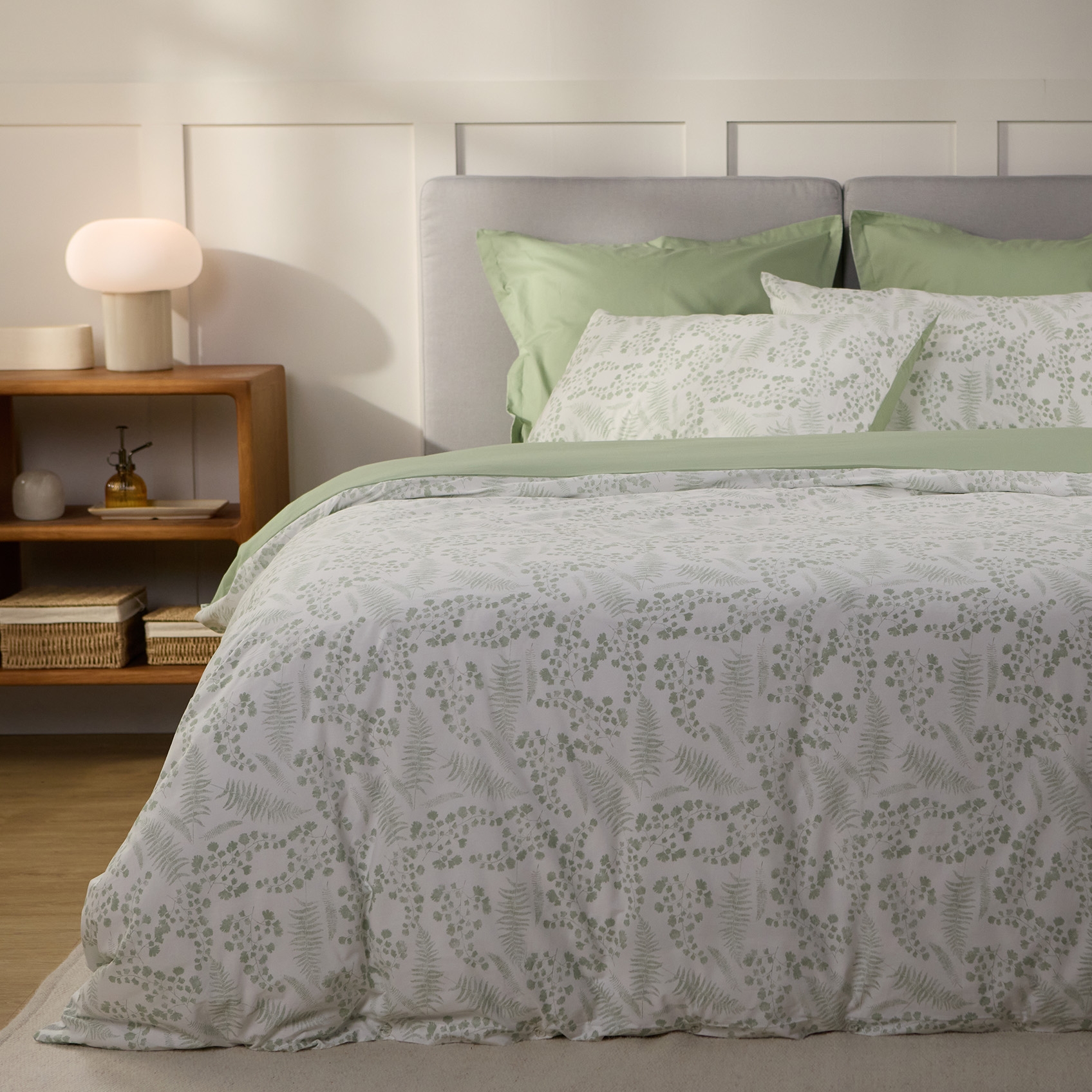 Chambre décorée avec lit, housse de couette et oreillers.