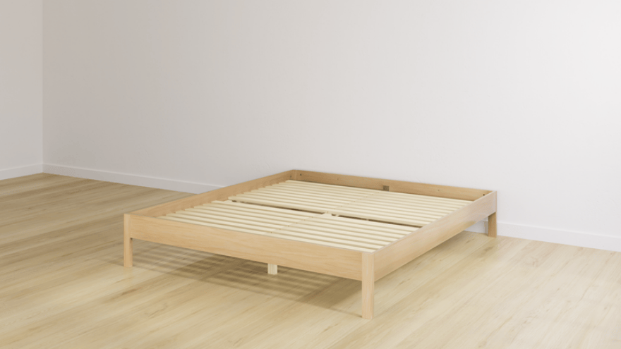 Minimalistisch houten bedframe van Emma geplaatst in een lichte slaapkamer met houten vloer en witte muren.