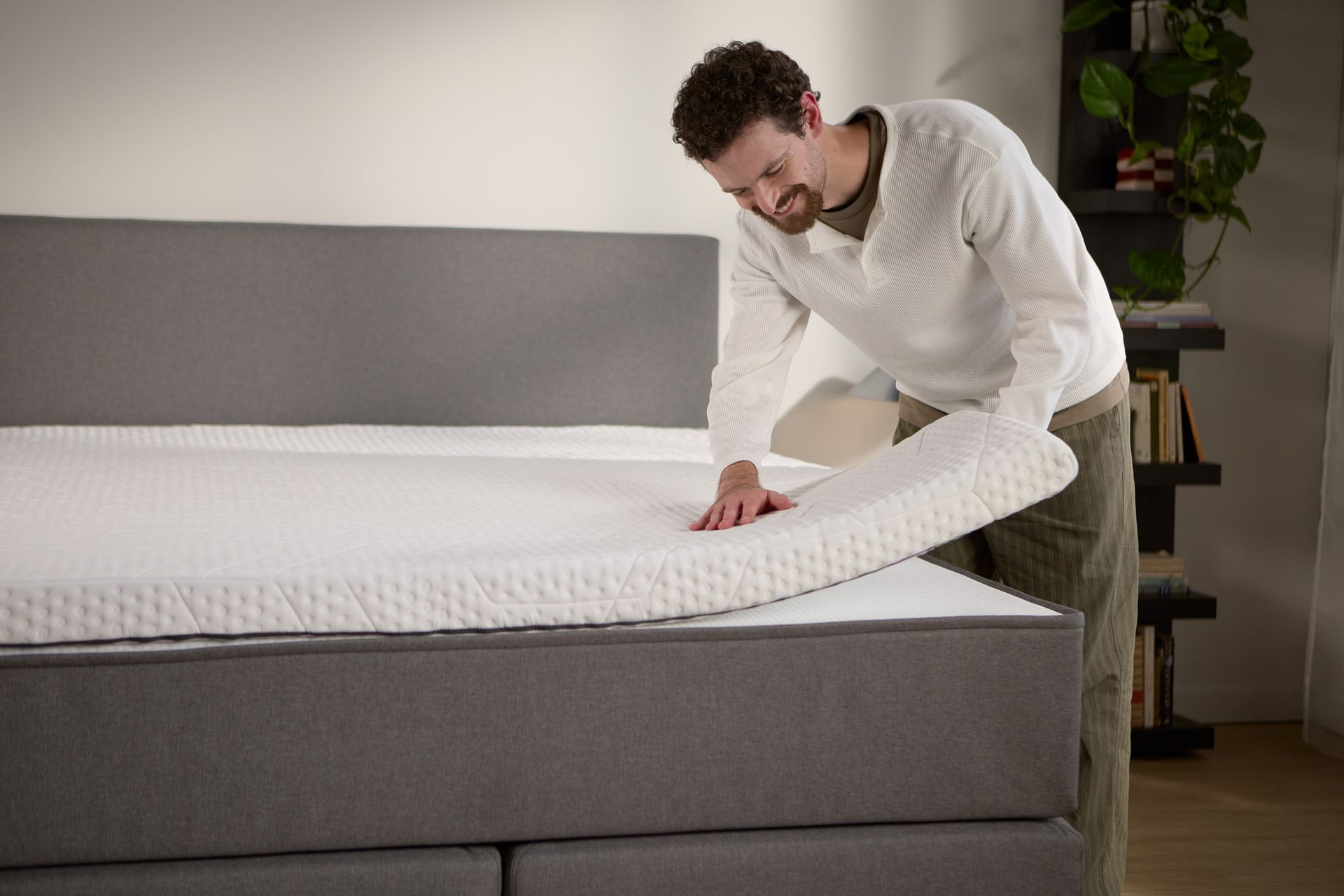 Detailaanzicht van een losse matrastopper die op het boxspringbed wordt opgetild, met extra comfort aan de bovenkant.