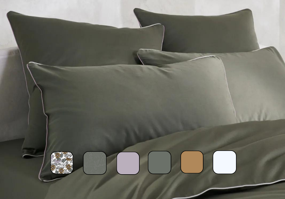 Image en gros plan d’un lit avec des oreillers et une housse de couette.