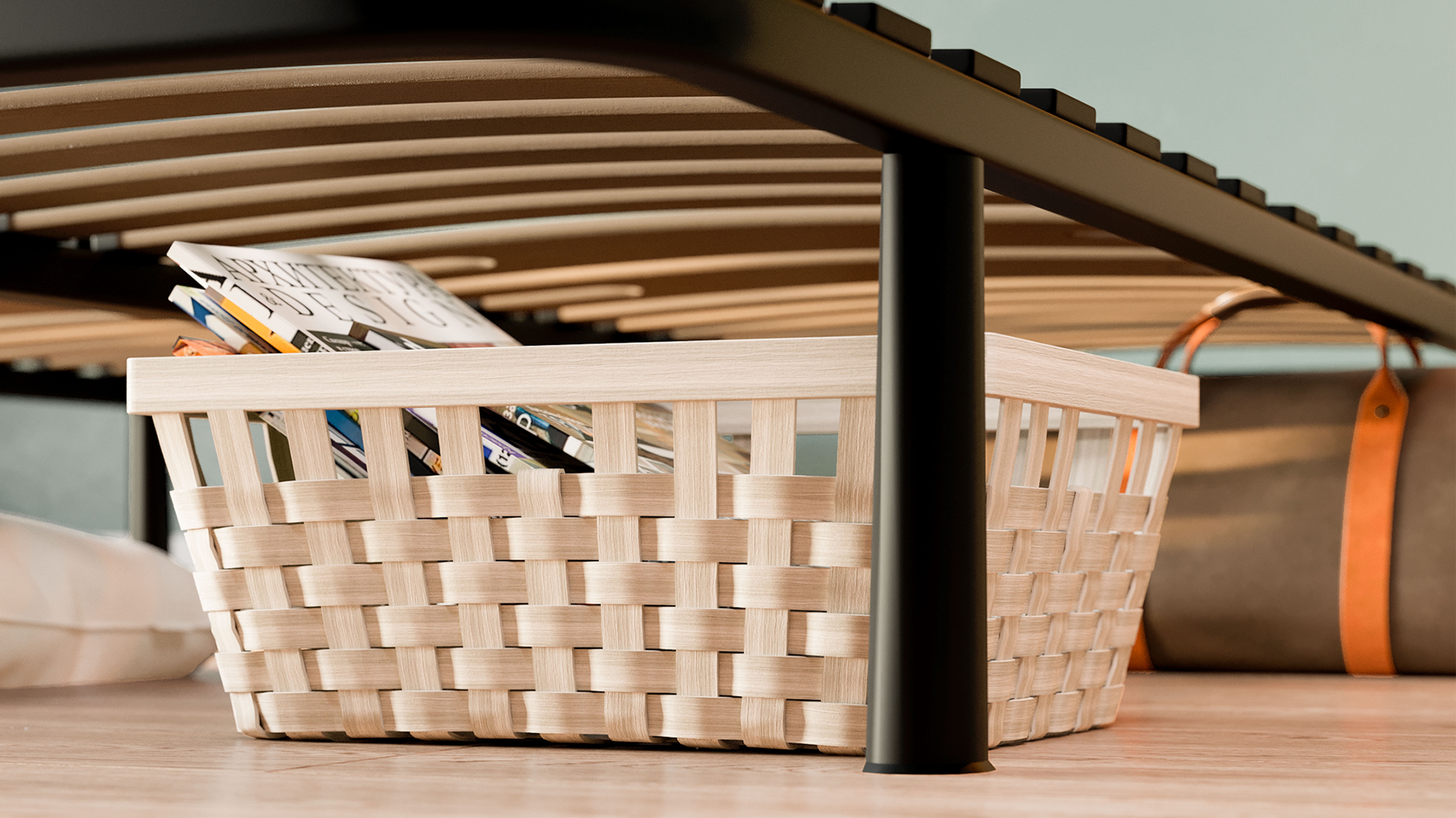 Cesto intrecciato sotto il letto con riviste e una borsa sullo sfondo.