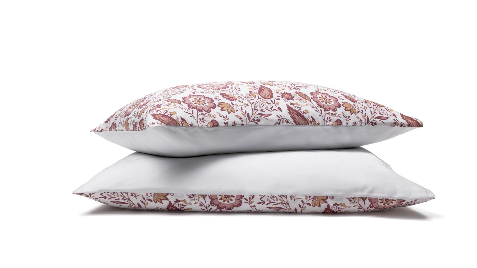 Due federe con motivo floreale rosso e rosa impilate su sfondo bianco.