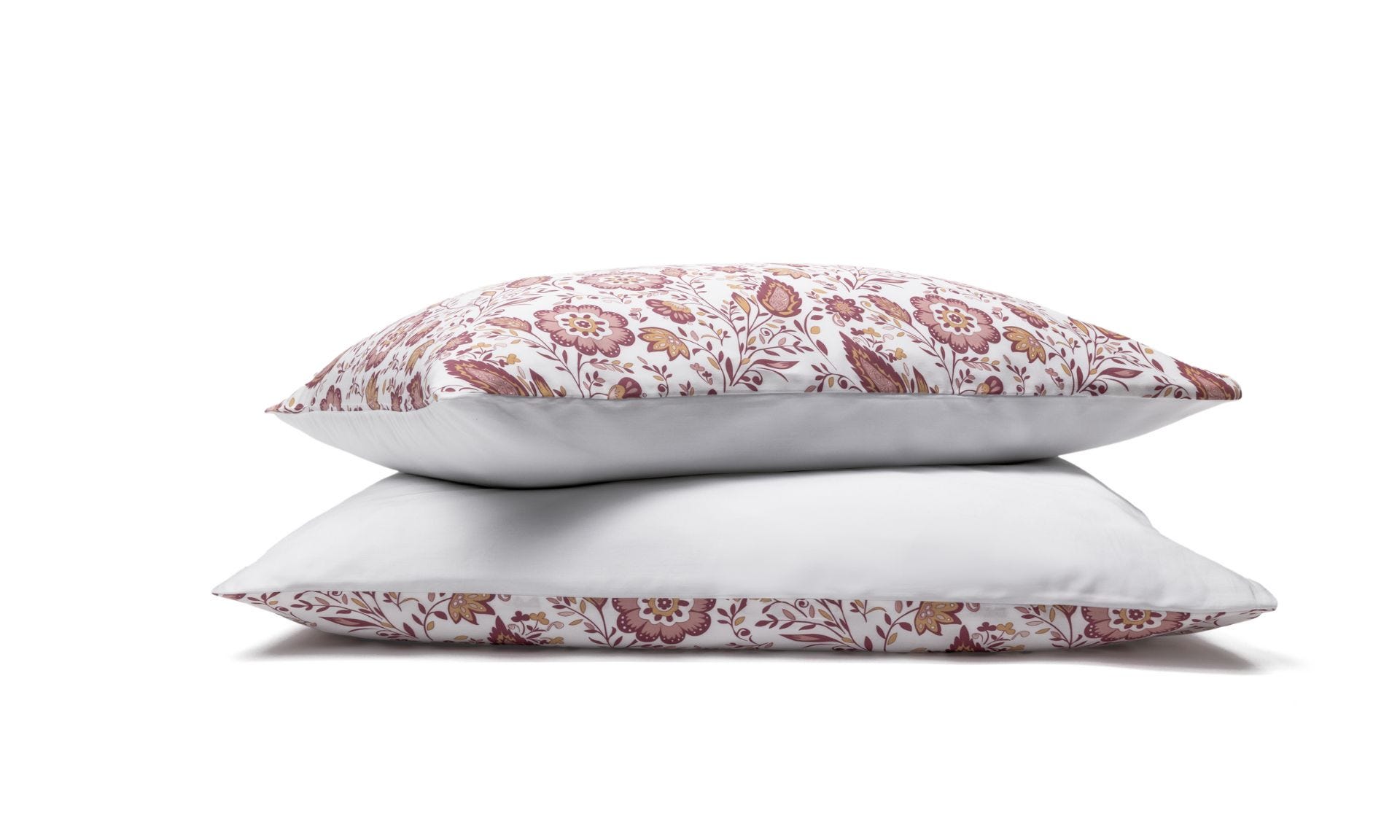 Due federe con motivo floreale rosso e rosa impilate su sfondo bianco.