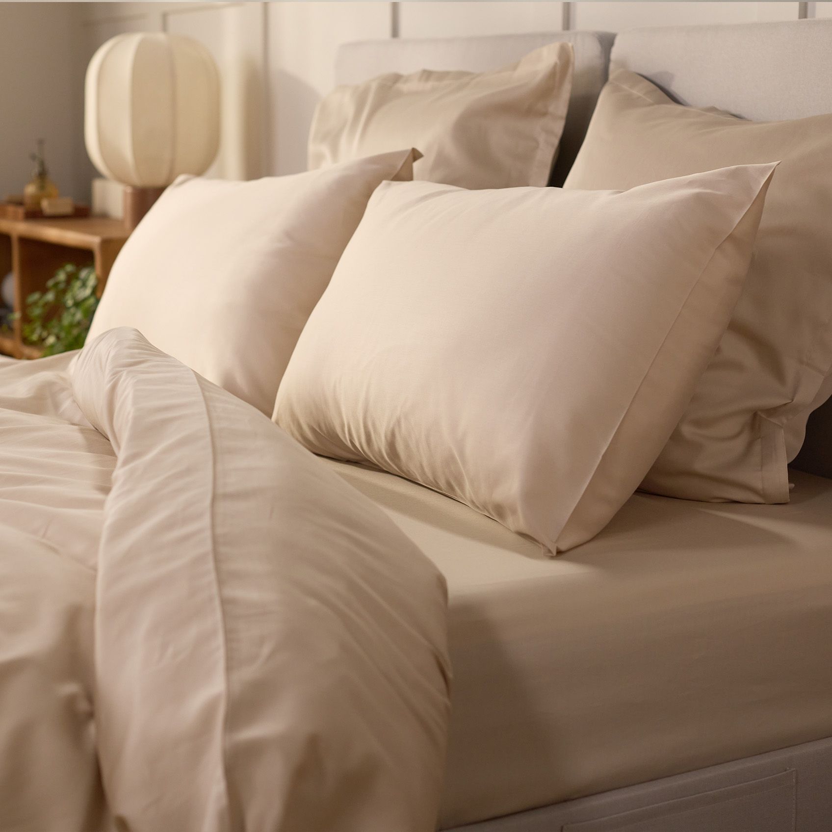 Image en gros plan d’un lit avec une housse de couette et quatre oreillers.