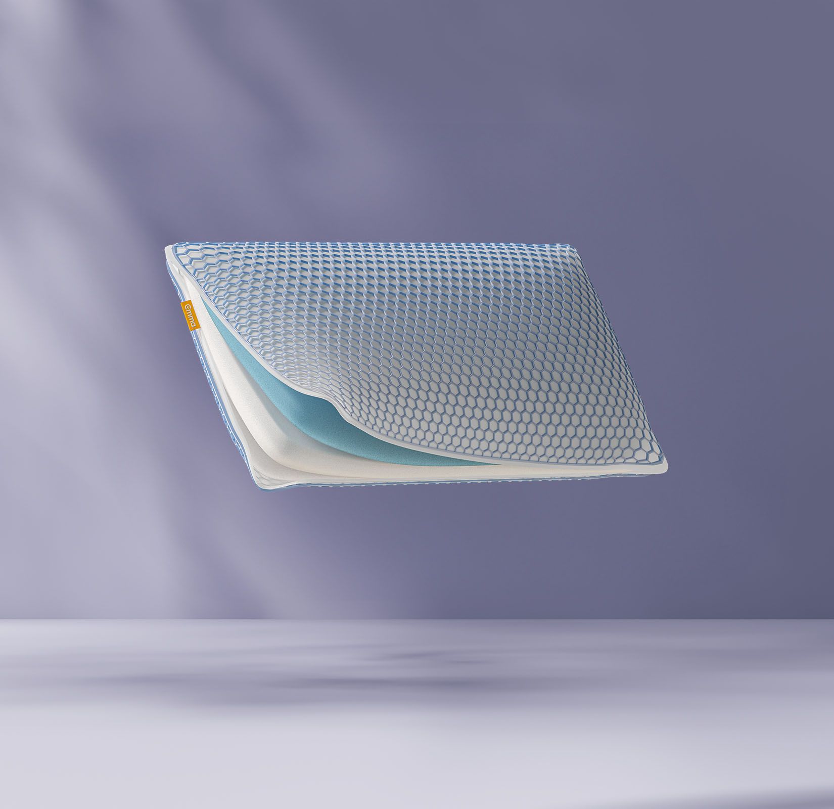 Oreiller flottant montrant ses couches de mousse internes avec un logo Emma. Fond violet clair.