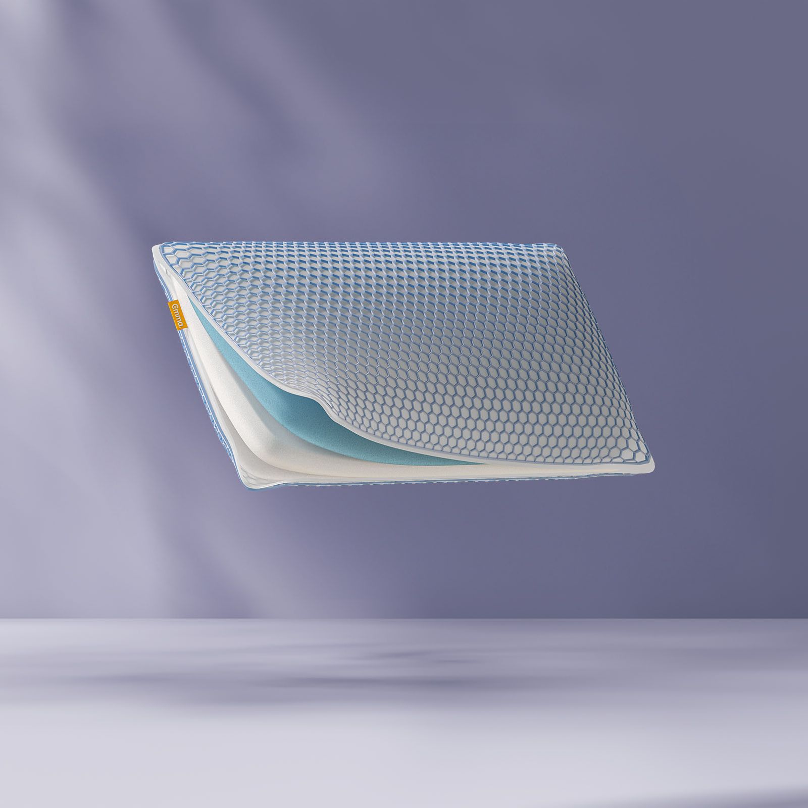 Oreiller flottant montrant ses couches de mousse internes avec un logo Emma. Fond violet clair.