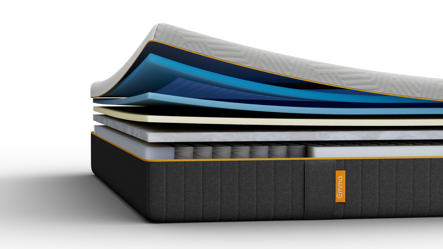 Lit tapissé gris avec matelas blanc, dans une chambre.