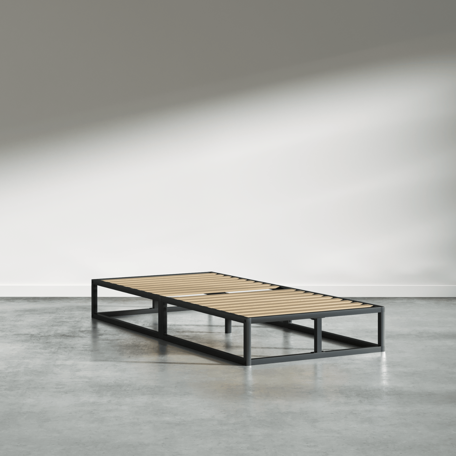 Eenpersoonsbed met een metalen frame en houten latten in een lege, licht verlichte ruimte.