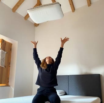 Vrouw gooit een Emma Diamond kussen in de lucht.