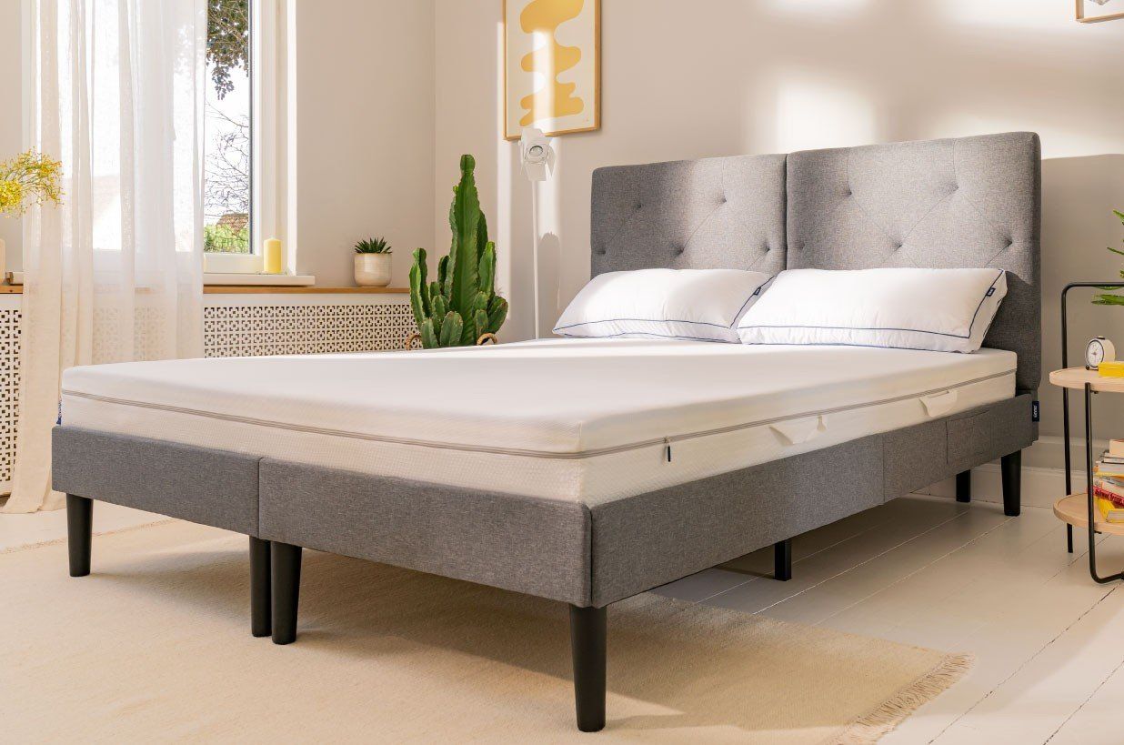 graues Bett mit Emma One Federkern Matratze und Flauschkissen