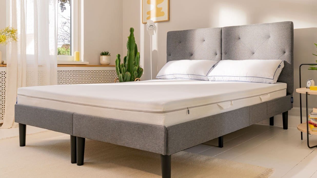 graues Bett mit Emma One Federkern Matratze und Flauschkissen