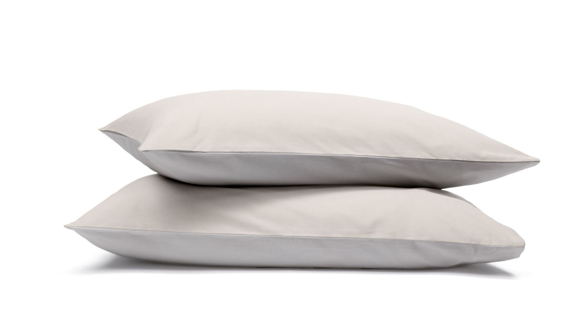 Due federe beige impilate su sfondo bianco.