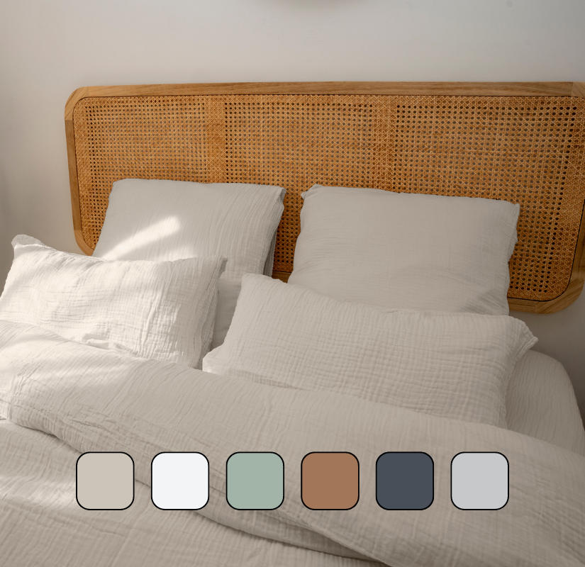 Image en gros plan d’un lit avec des oreillers et une housse de couette.