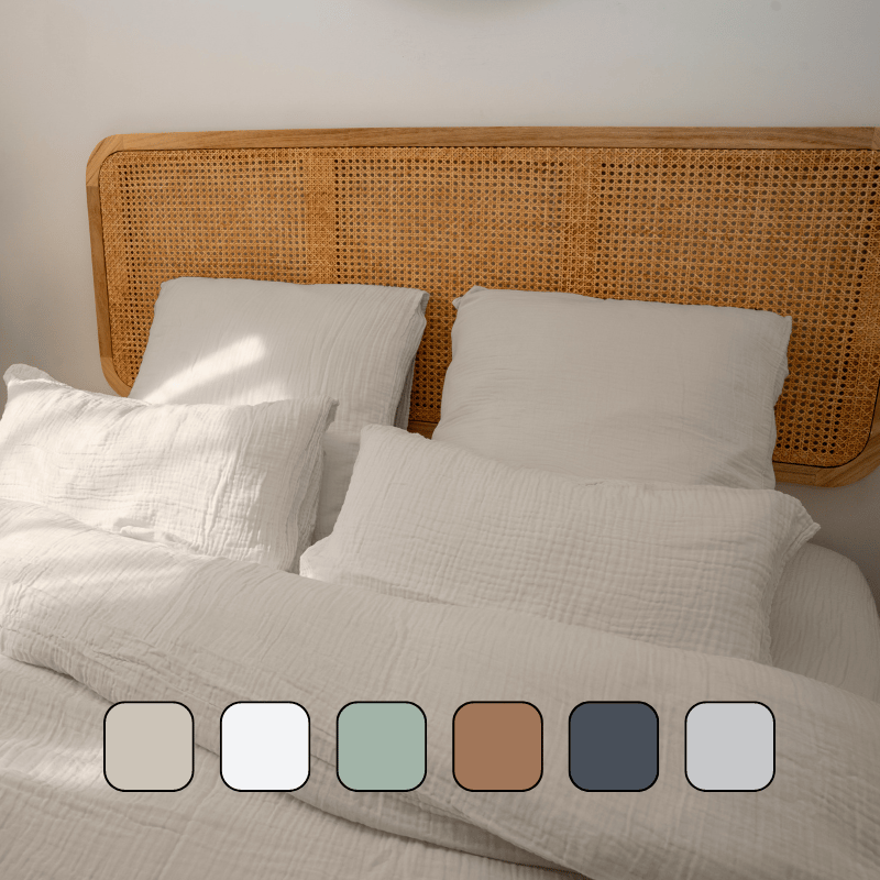 Image en gros plan d’un lit avec des oreillers et une housse de couette.