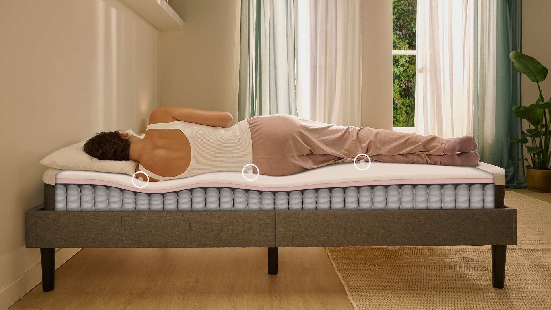 Person lying on their side on a white mattress in a relaxed sleeping position.