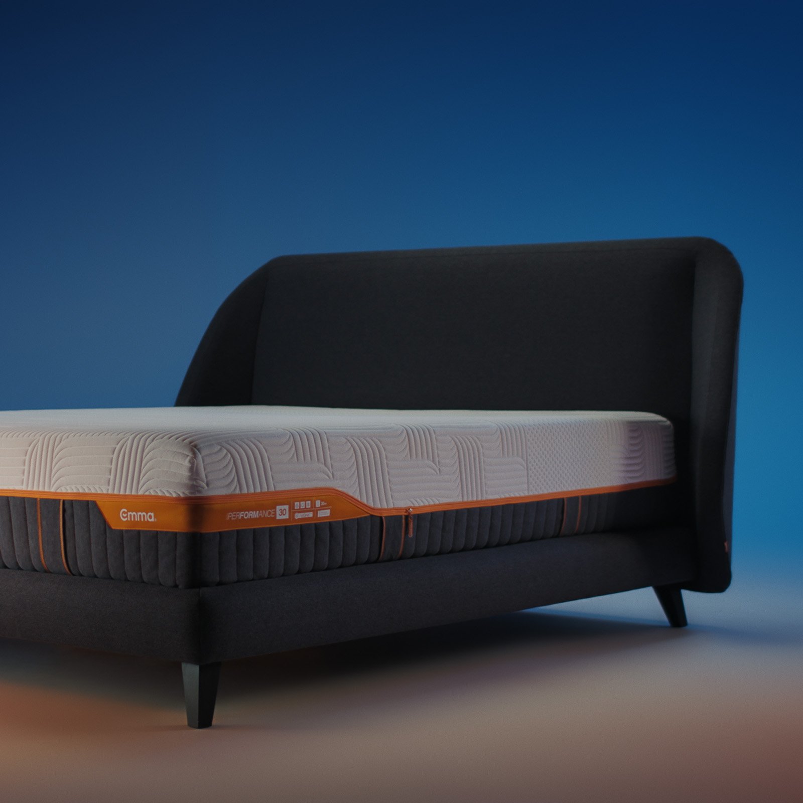 Emma Performance boxspringbed with charcoal upholstered curved headboard, matching base, and black tapered legs.
