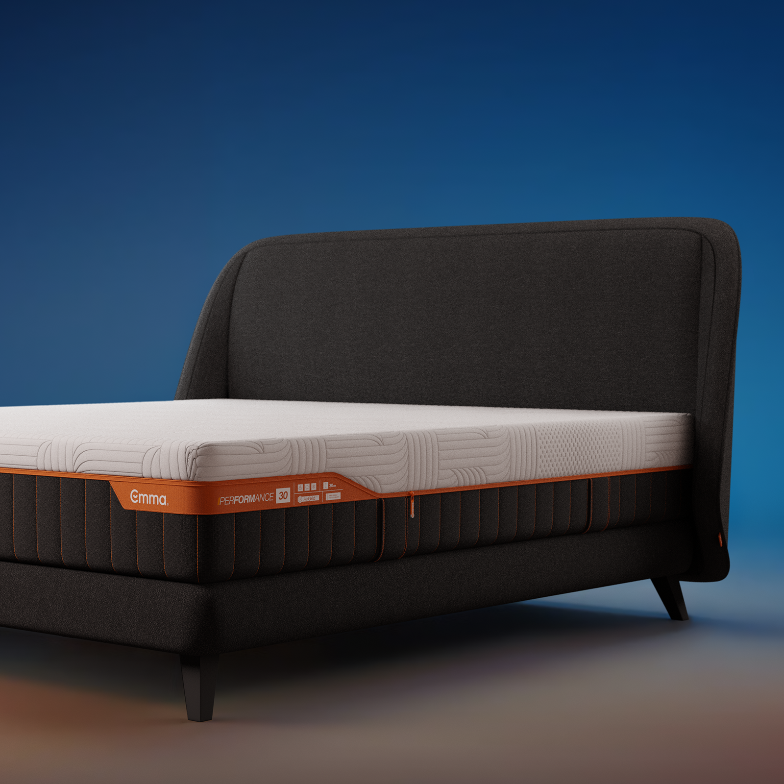 Emma Performance boxspringbed with charcoal upholstered curved headboard, matching base, and black tapered legs.