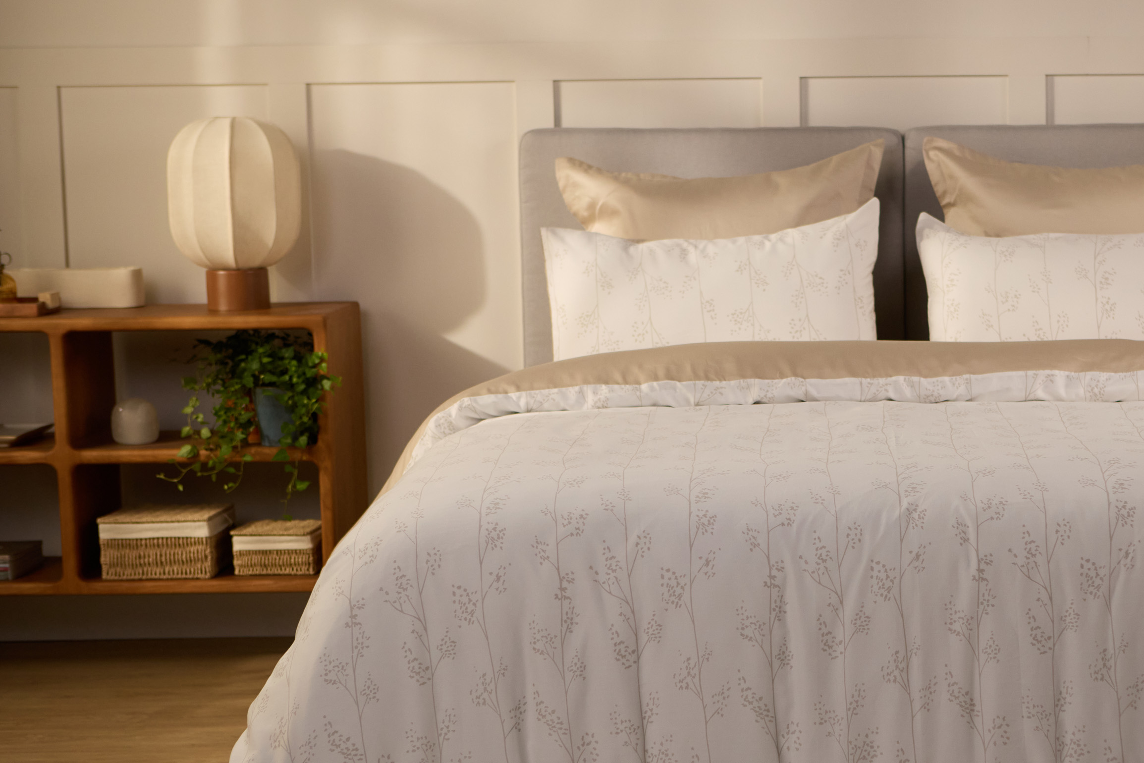 Vue de face d’une chambre décorée, avec un lit doté d’une couette colorée et de taies d’oreiller.