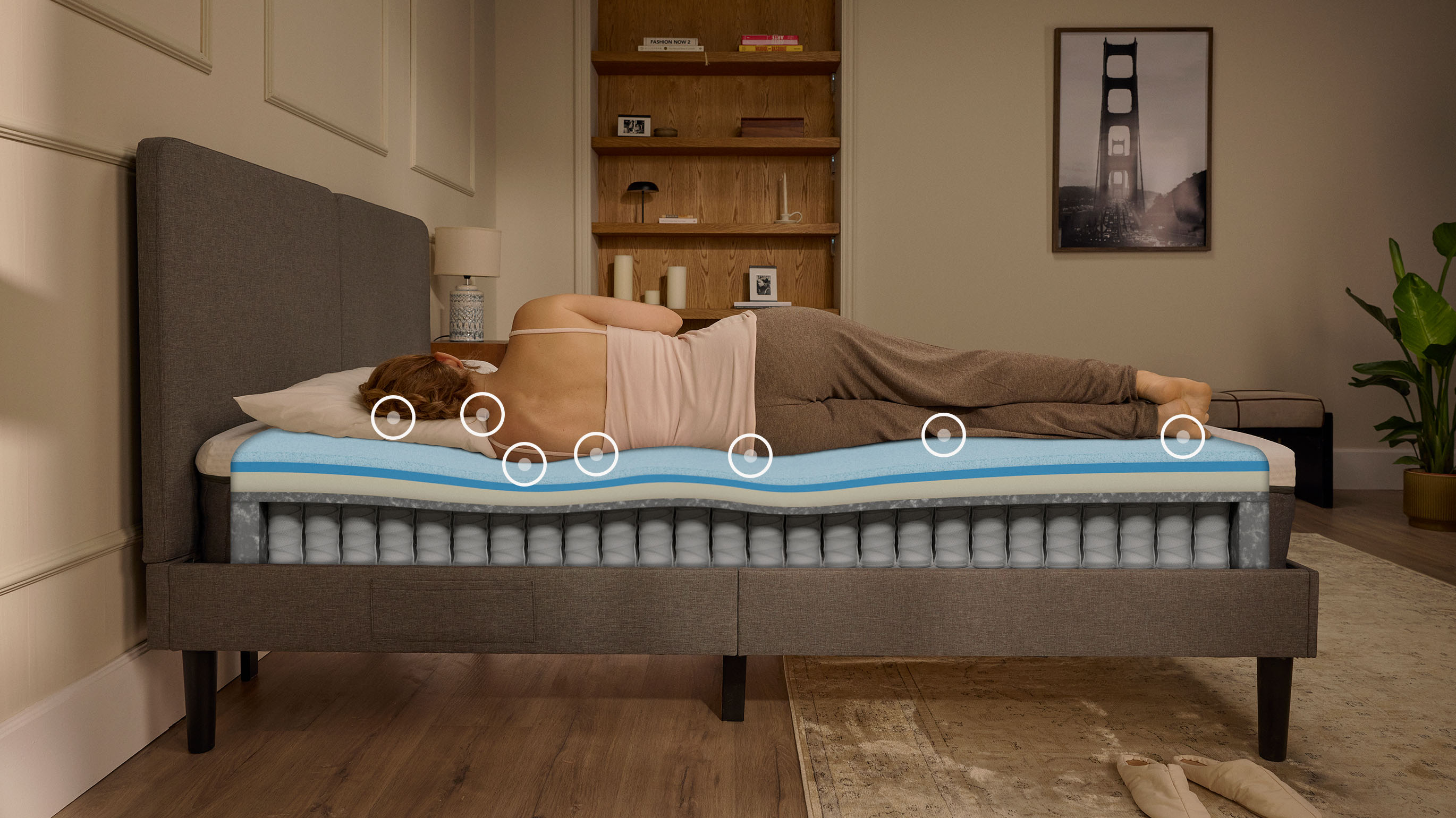 Une femme endormie sur le côté sur un matelas Emma Original Pro, avec une vue en coupe montrant la structure en mousse et à ressorts sous elle.