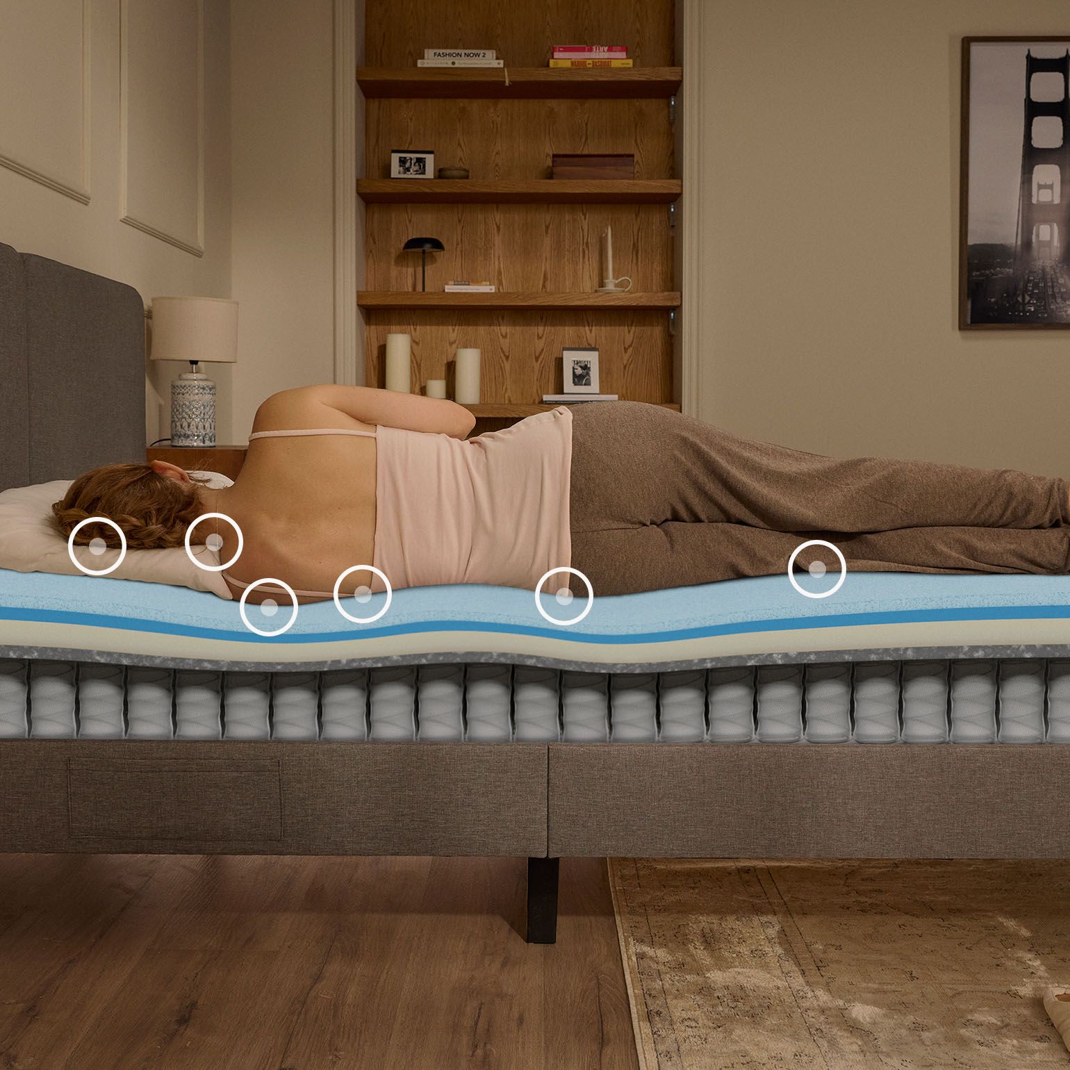 Une femme endormie sur le côté sur un matelas Emma Original Pro, avec une vue en coupe montrant la structure en mousse et à ressorts sous elle.