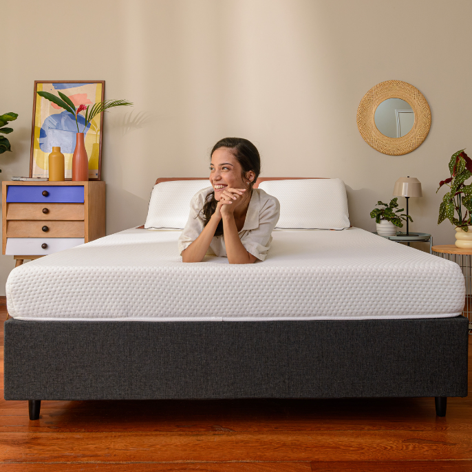 Persona acostada sobre una cama con la cabeza apoyada en las manos.