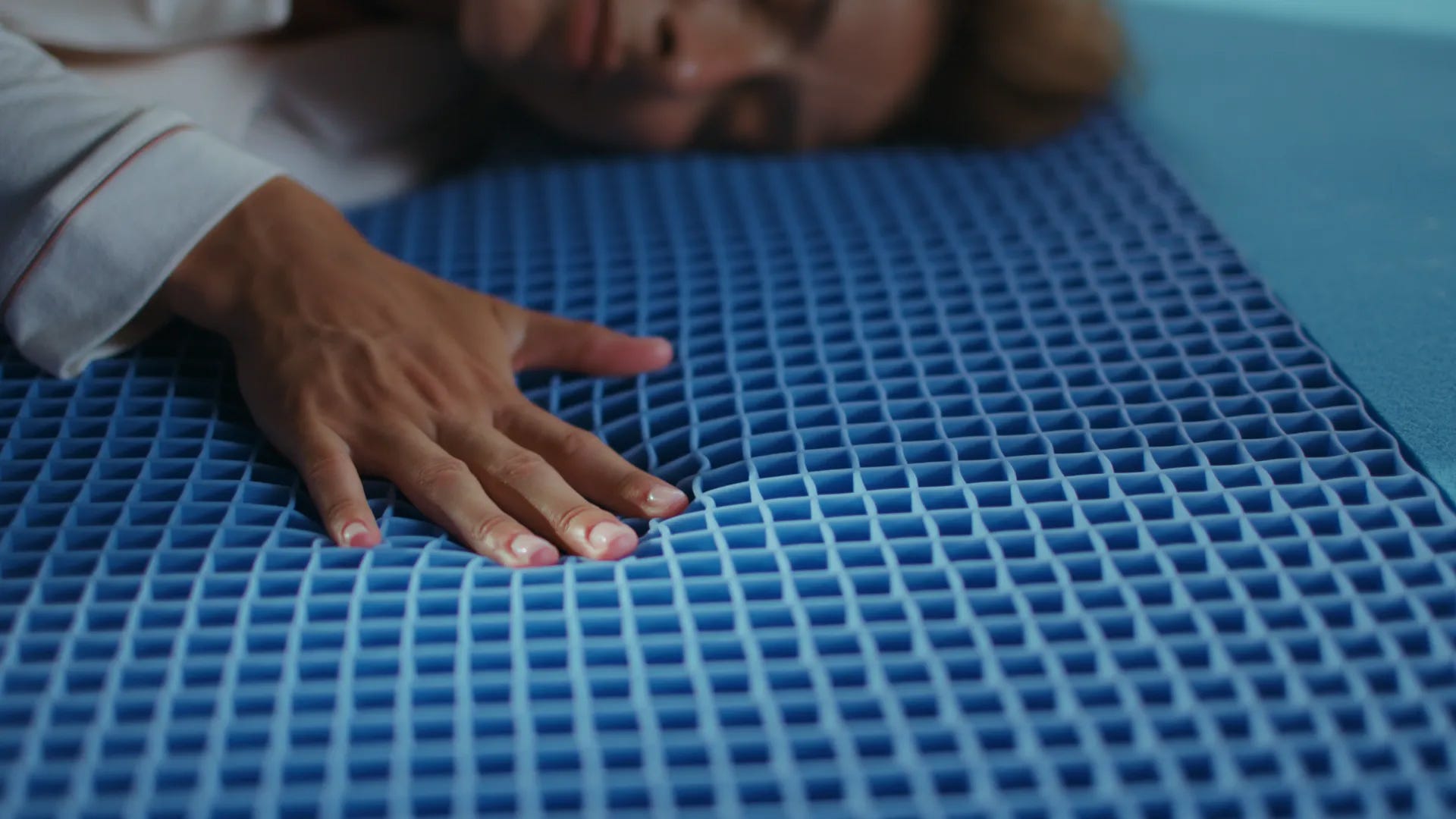 Hand pressing down an airgrid foam layer.