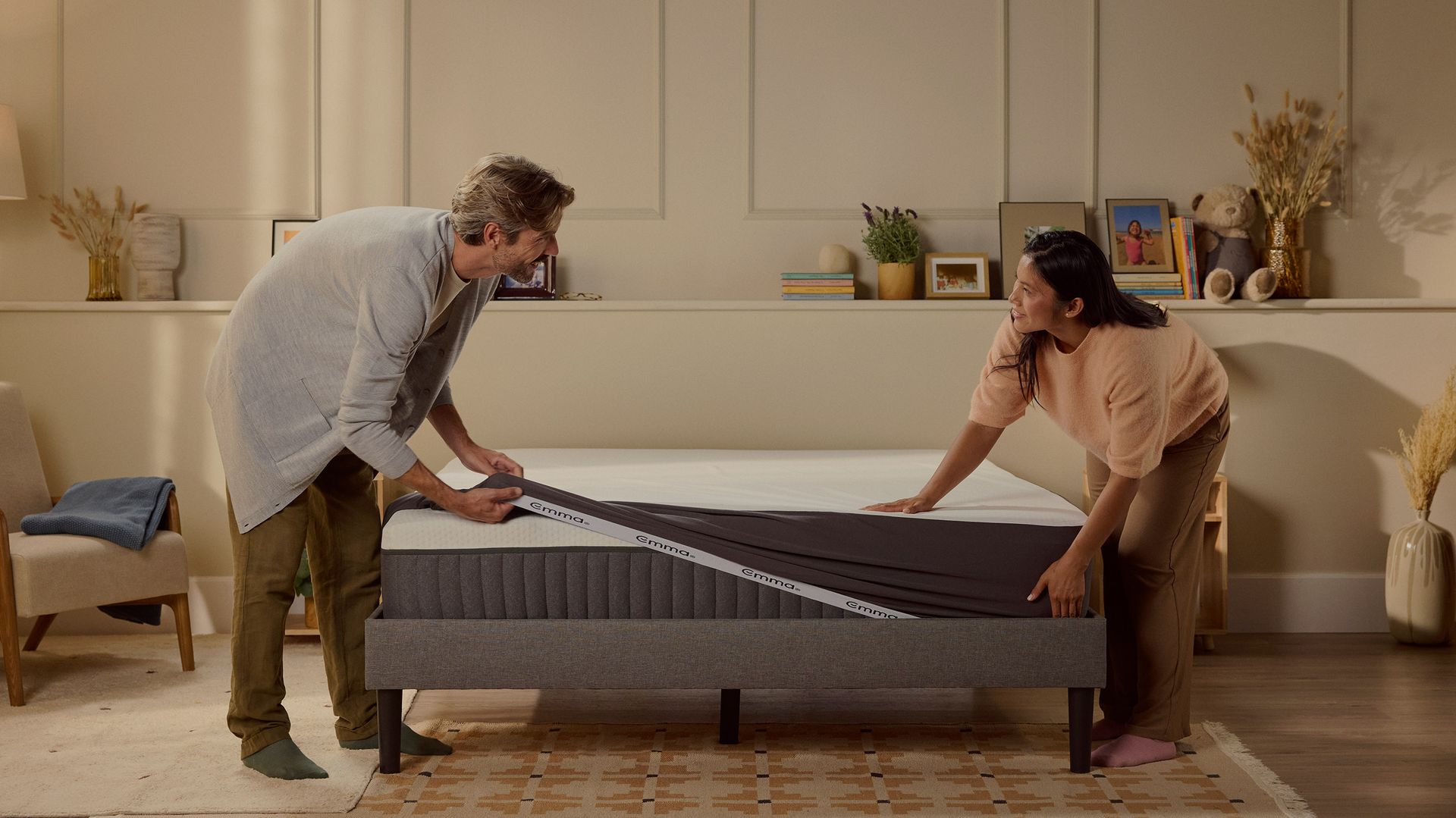 Due persone che sistemano un coprimaterasso su un materasso