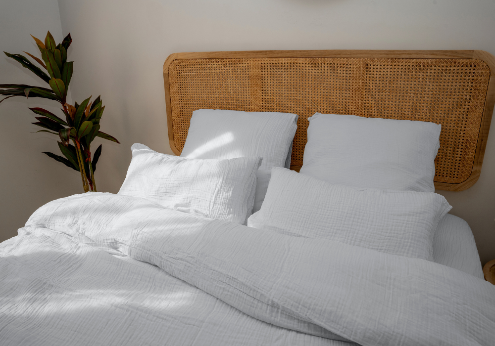 Gros plan sur des oreillers avec des taies colorées posés sur un lit.